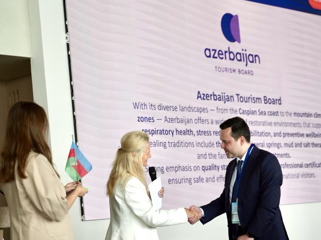 Two professionals shaking hands at Azerbaijan Tourism Board conference event