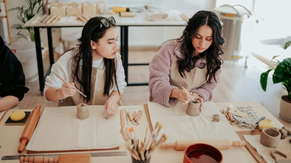Two women collaborating on artwork and planning at a creative studio workspace