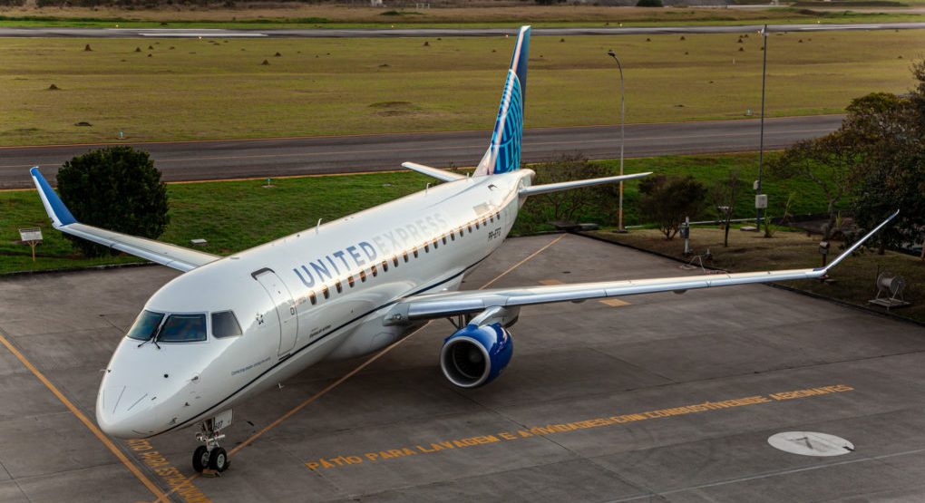 United Express regional jet sits on a runway with a cloudy sky.