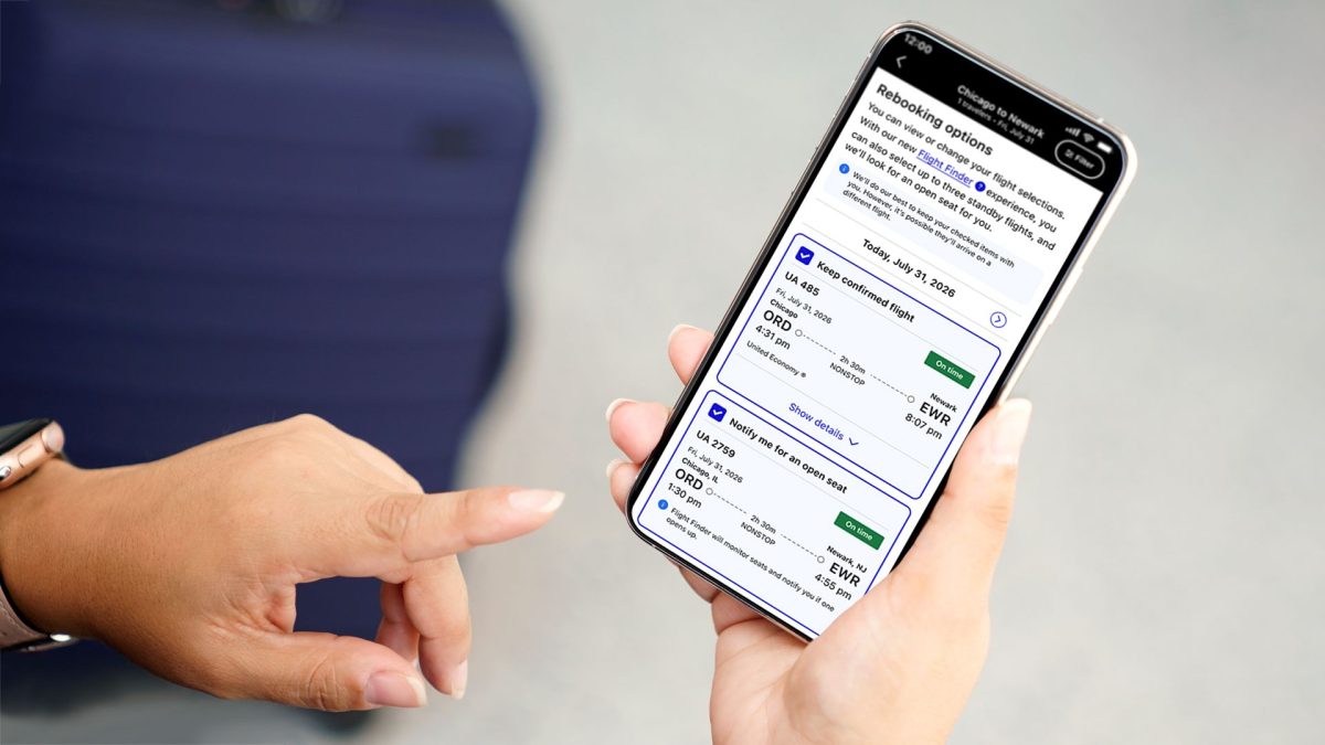 Person holding smartphone displaying United Airlines app with flight booking options
