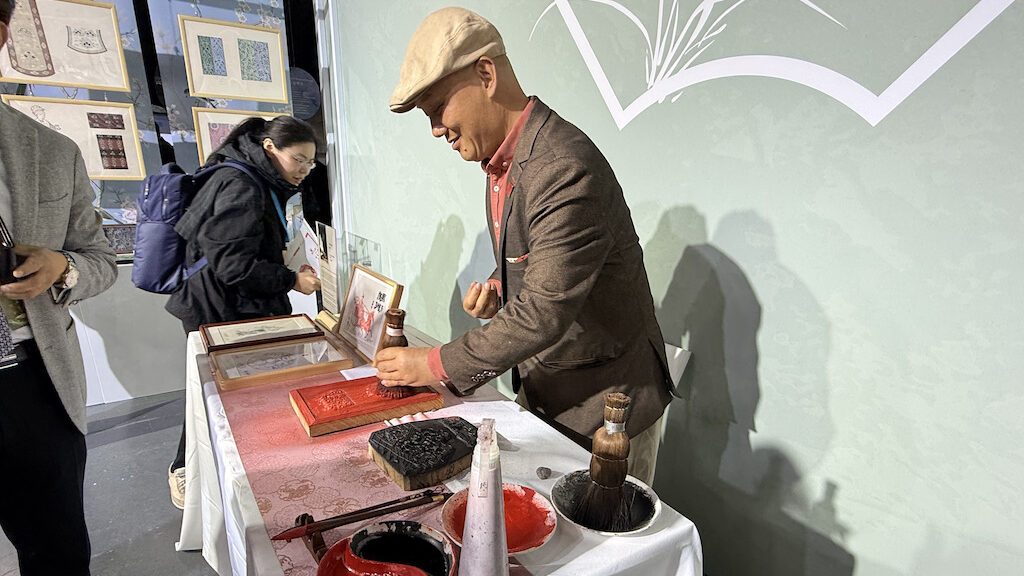 Visitor examining traditional Zhejiang crafts at Brussels cultural exhibition
