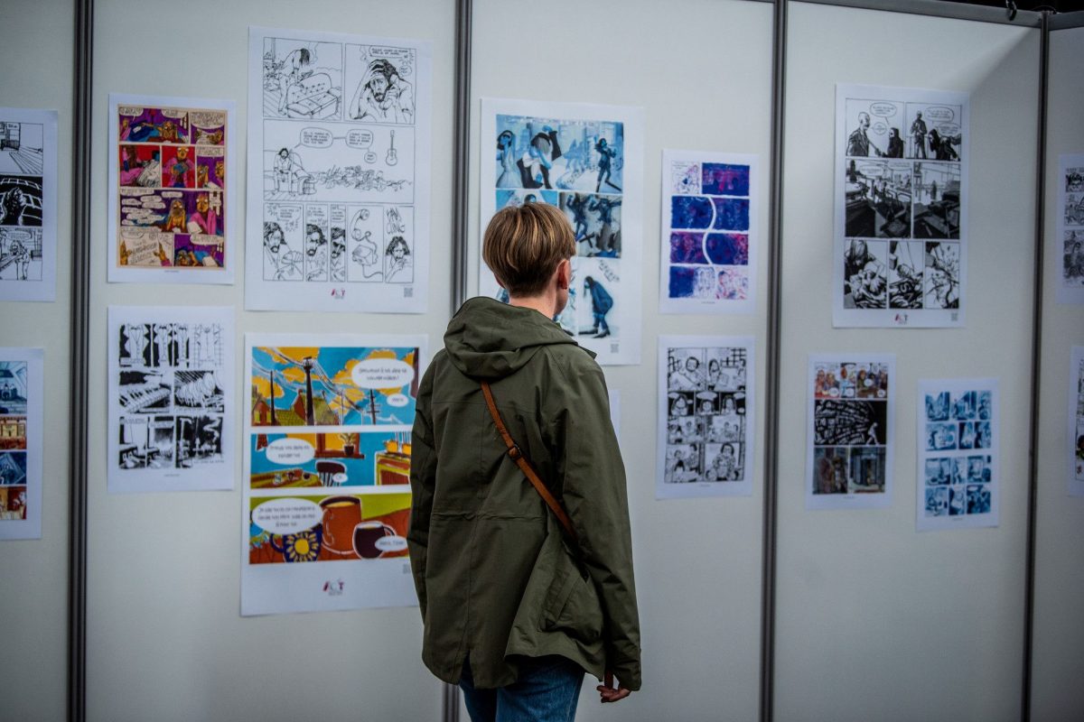 Visitor viewing comic strip artwork displayed on gallery walls