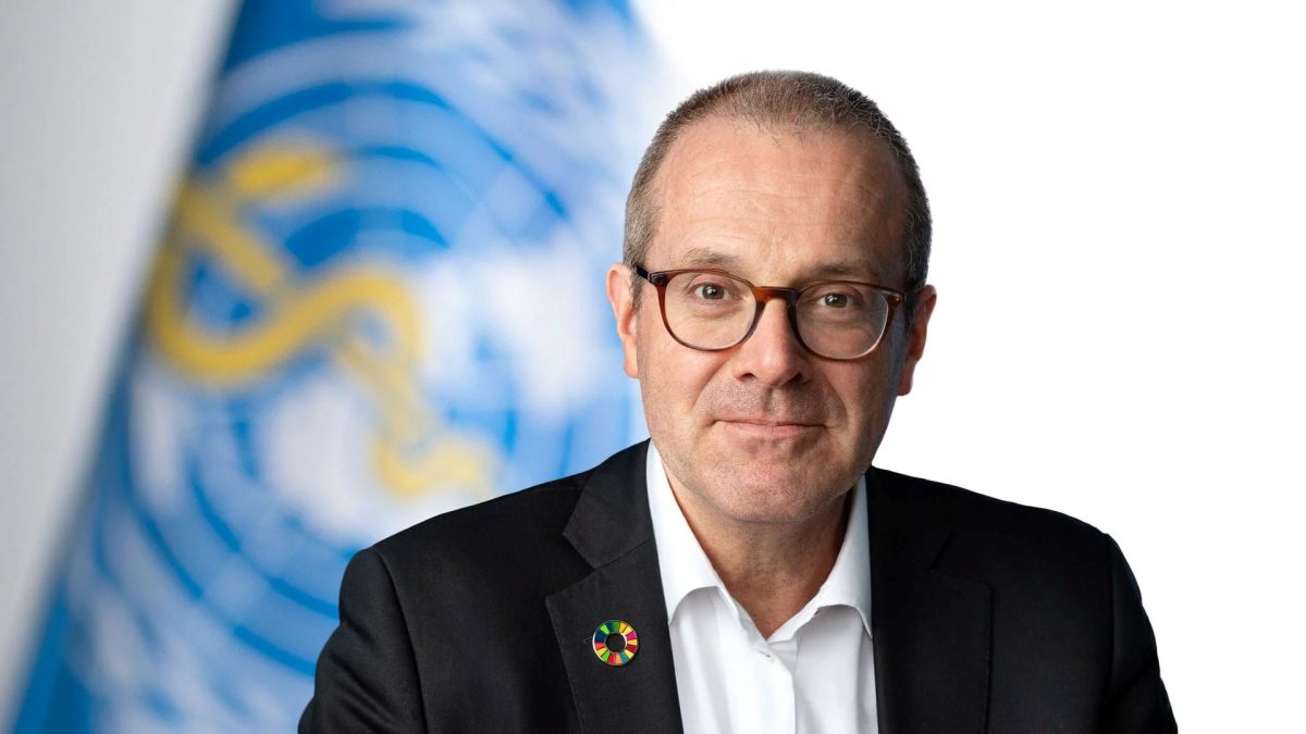 WHO official in formal attire with organization logo in background