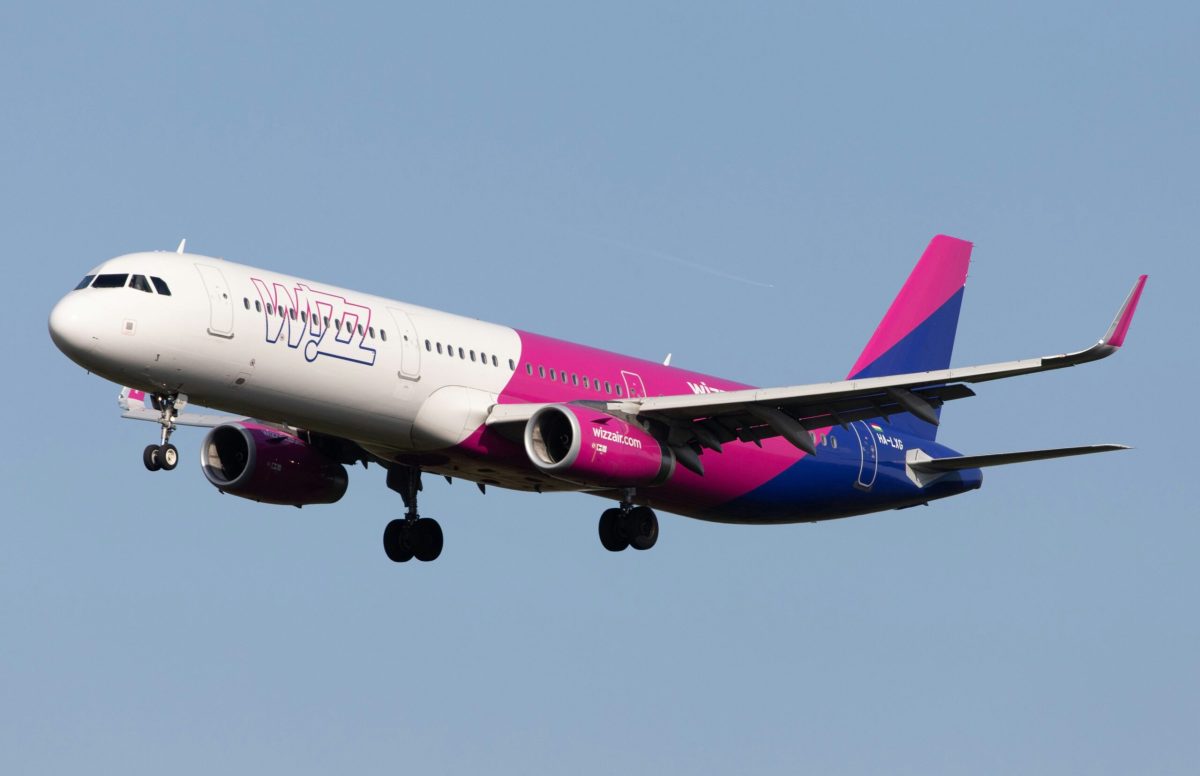 Wizz Air Airbus A321 in flight with distinctive magenta and blue livery