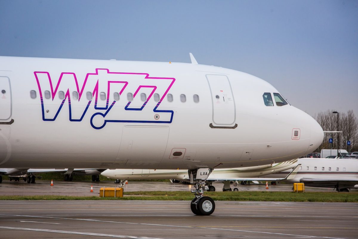 Wizz Air aircraft parked on tarmac with distinctive purple branding on fuselage