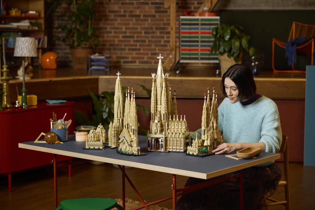 Woman admiring detailed LEGO Sagrada Família model on display table