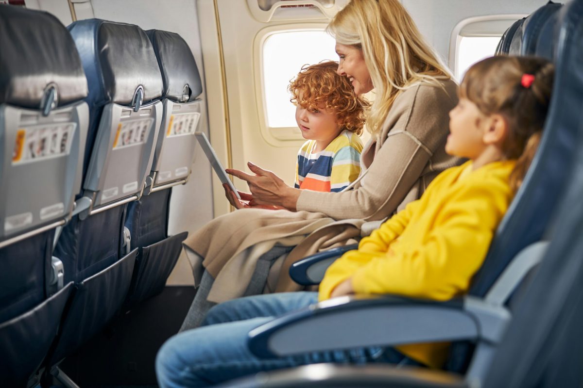 Woman and children sitting in airplane seats during flight