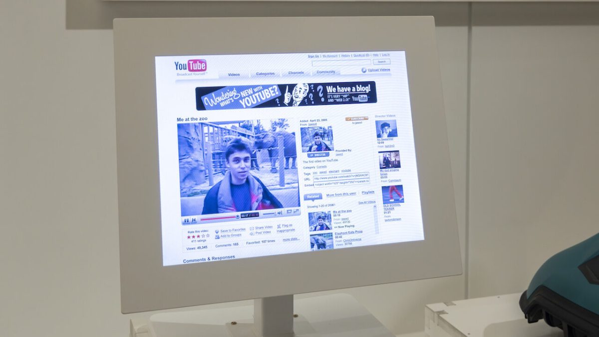 YouTube's homepage displayed on a museum exhibition screen showing the historic first video