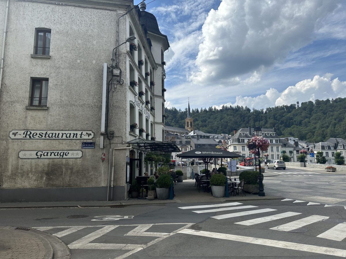 Zebra crossing in Bouillon town center with historic buildings and forested hills